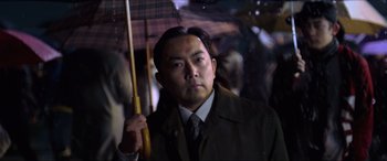 Movie still from “Resident Evil: Retribution” (2012), directed by Paul W.S. Anderson – A man holding an umbrella while standing in the rain; Close Up shot, Low angle