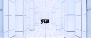 Movie still from “Resident Evil: Retribution” (2012), directed by Paul W.S. Anderson – A group of people walking through a white hallway; Extreme Wide shot, High angle