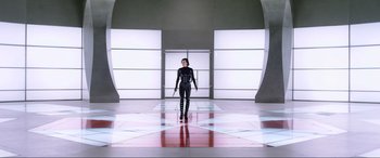 Movie still from “Resident Evil: Retribution” (2012), directed by Paul W.S. Anderson – A woman dressed in black holding a gun in a room; Wide shot, Low angle