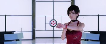 Movie still from “Resident Evil: Retribution” (2012), directed by Paul W.S. Anderson – A woman in a red dress is holding a red object; Close Up shot, Over the shoulder angle