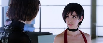 Movie still from “Resident Evil: Retribution” (2012), directed by Paul W.S. Anderson – A woman with short hair wearing a black choker; Close Up shot, Over the shoulder angle