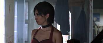 Movie still from “Resident Evil: Retribution” (2012), directed by Paul W.S. Anderson – A woman in a red top and a black choker; Close Up shot, Over the shoulder angle