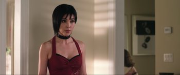 Movie still from “Resident Evil: Retribution” (2012), directed by Paul W.S. Anderson – A woman in a red dress with a black choker around her neck; Close Up shot, Over the shoulder angle