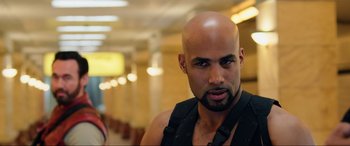 Movie still from “Resident Evil: Retribution” (2012), directed by Paul W.S. Anderson – A man with a bald head in a hallway; Close Up shot, Over the shoulder angle