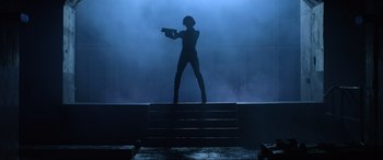 Movie still from “Resident Evil: Retribution” (2012), directed by Paul W.S. Anderson – A woman standing on a platform holding a gun; Wide shot, Low angle
