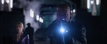 Movie still from “Resident Evil: Retribution” (2012), directed by Paul W.S. Anderson – A bald man holding a flashlight in his hand; Medium shot, Low angle
