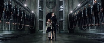 Movie still from “Resident Evil: Retribution” (2012), directed by Paul W.S. Anderson – A woman and a girl standing next to each other in front of a building; Wide shot, Low angle