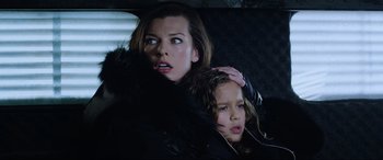 Movie still from “Resident Evil: Retribution” (2012), directed by Paul W.S. Anderson – A woman and a child in the back of a car; Close Up shot, Low angle