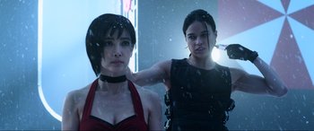 Movie still from “Resident Evil: Retribution” (2012), directed by Paul W.S. Anderson – Two young women posing for a picture in a dark room; Close Up shot, Over the shoulder angle