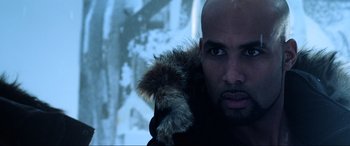 Movie still from “Resident Evil: Retribution” (2012), directed by Paul W.S. Anderson – A bald man with a fur coat is looking at the camera; Close Up shot, Over the shoulder angle