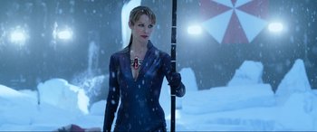 Movie still from “Resident Evil: Retribution” (2012), directed by Paul W.S. Anderson – A woman holding a pole in the snow; Medium shot, Over the shoulder angle