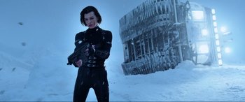 Movie still from “Resident Evil: Retribution” (2012), directed by Paul W.S. Anderson – A woman holding a gun while standing in the snow; Medium shot, Low angle