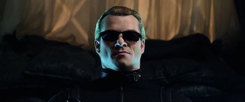 Movie still from “Resident Evil: Retribution” (2012), directed by Paul W.S. Anderson – A person wearing sunglasses; Close Up shot, Low angle