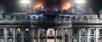 Movie still from “Resident Evil: Retribution” (2012), directed by Paul W.S. Anderson – A building that has been set on fire; Extreme Wide shot, Low angle