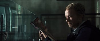 Movie still from “Resident Evil: The Final Chapter” (2016), directed by Paul W.S. Anderson – A man reading a magazine in a dark room; Close Up shot, Low angle