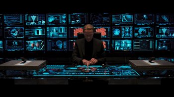 Movie still from “Resident Evil: The Final Chapter” (2016), directed by Paul W.S. Anderson – A man sitting at a desk in front of a computer screen; Medium shot, High angle