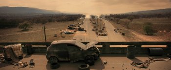 Movie still from “Resident Evil: The Final Chapter” (2016), directed by Paul W.S. Anderson – A car that has been wrecked on the side of the road; Extreme Wide shot, High angle
