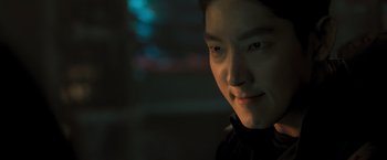 Movie still from “Resident Evil: The Final Chapter” (2016), directed by Paul W.S. Anderson – A young man is smiling for the camera; Close Up shot, Over the shoulder angle