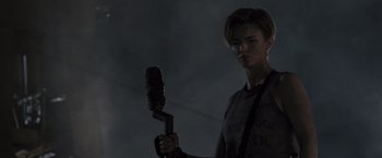 Movie still from “Resident Evil: The Final Chapter” (2016), directed by Paul W.S. Anderson – A person holding a brush in a dark room; Medium shot, Over the shoulder angle