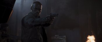Movie still from “Resident Evil: The Final Chapter” (2016), directed by Paul W.S. Anderson – A man holding a gun while standing in a dark room; Medium shot, Low angle