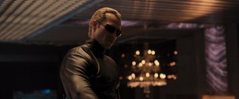 Movie still from “Resident Evil: The Final Chapter” (2016), directed by Paul W.S. Anderson – A man wearing sunglasses and a leather jacket; Medium shot, Low angle