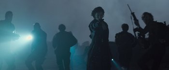 Movie still from “Resident Evil: The Final Chapter” (2016), directed by Paul W.S. Anderson – A woman is pointing at the camera in the fog; Medium shot, Over the shoulder angle