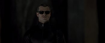 Movie still from “Resident Evil: The Final Chapter” (2016), directed by Paul W.S. Anderson – A man wearing sunglasses and a black jacket; Close Up shot, Low angle