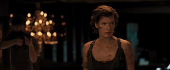 Movie still from “Resident Evil: The Final Chapter” (2016), directed by Paul W.S. Anderson – A person wearing a tank top; Medium shot, Over the shoulder angle