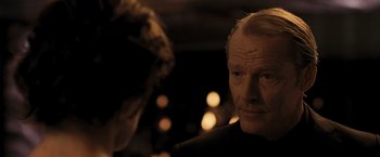 Movie still from “Resident Evil: The Final Chapter” (2016), directed by Paul W.S. Anderson – An older man is looking at a blurry image; Close Up shot, Over the shoulder angle