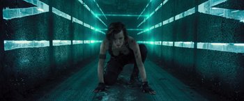 Movie still from “Resident Evil: The Final Chapter” (2016), directed by Paul W.S. Anderson – A woman crouching down in an empty room; Medium shot, Low angle