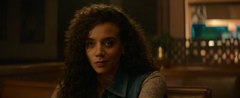 Movie still from “Resident Evil: Welcome to Raccoon City” (2021), directed by Johannes Roberts – A person with long curly hair; Close Up shot, Over the shoulder angle