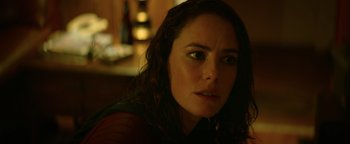 Movie still from “Resident Evil: Welcome to Raccoon City” (2021), directed by Johannes Roberts – A woman's face in a dark room; Close Up shot, Over the shoulder angle