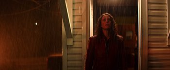 Movie still from “Resident Evil: Welcome to Raccoon City” (2021), directed by Johannes Roberts – A woman standing in the rain looking up at the sky; Medium shot, Low angle