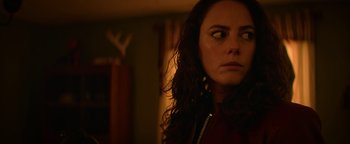 Movie still from “Resident Evil: Welcome to Raccoon City” (2021), directed by Johannes Roberts – A person with long curly hair; Close Up shot, Over the shoulder angle