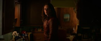 Movie still from “Resident Evil: Welcome to Raccoon City” (2021), directed by Johannes Roberts – A woman wearing a leather jacket standing in a room; Medium shot, Low angle