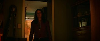 Movie still from “Resident Evil: Welcome to Raccoon City” (2021), directed by Johannes Roberts – A woman standing in a doorway in a dark room; Medium shot, Low angle