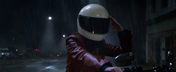 Movie still from “Resident Evil: Welcome to Raccoon City” (2021), directed by Johannes Roberts – A person wearing a motorcycle helmet in the rain; Close Up shot, High angle
