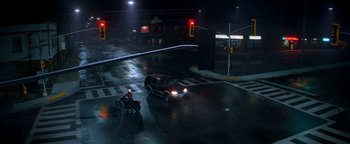 Movie still from “Resident Evil: Welcome to Raccoon City” (2021), directed by Johannes Roberts – A car and a motorcycle on a street at night; Extreme Wide shot, High angle