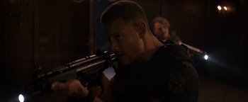 Movie still from “Resident Evil: Welcome to Raccoon City” (2021), directed by Johannes Roberts – A person holding a gun; Close Up shot, Over the shoulder angle