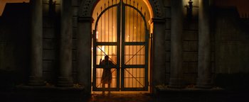Movie still from “Resident Evil: Welcome to Raccoon City” (2021), directed by Johannes Roberts – A person standing in front of a door; Extreme Wide shot, Low angle