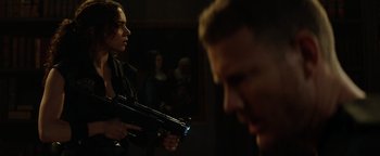 Movie still from “Resident Evil: Welcome to Raccoon City” (2021), directed by Johannes Roberts – A man and a woman holding guns in a dark room; Medium shot, Over the shoulder angle