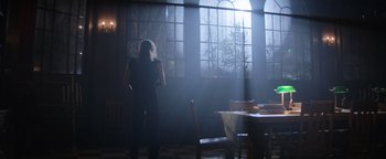 Movie still from “Resident Evil: Welcome to Raccoon City” (2021), directed by Johannes Roberts – A woman standing in front of a window in a room; Wide shot, Low angle