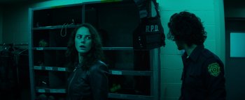 Movie still from “Resident Evil: Welcome to Raccoon City” (2021), directed by Johannes Roberts – A woman standing in front of an oven in a dark room; Medium shot, Over the shoulder angle