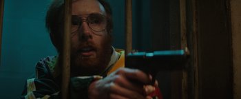 Movie still from “Resident Evil: Welcome to Raccoon City” (2021), directed by Johannes Roberts – A man with a beard is holding a cell phone; Close Up shot, Low angle