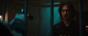 Movie still from “Resident Evil: Welcome to Raccoon City” (2021), directed by Johannes Roberts – A man standing next to a wall in a dark room; Close Up shot, Over the shoulder angle