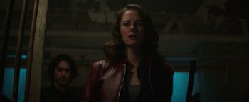 Movie still from “Resident Evil: Welcome to Raccoon City” (2021), directed by Johannes Roberts – A woman wearing a red leather jacket looking to her left; Close Up shot, Low angle