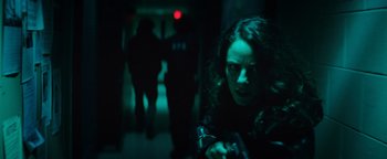 Movie still from “Resident Evil: Welcome to Raccoon City” (2021), directed by Johannes Roberts – A woman in black jacket holding a camera; Close Up shot, Low angle