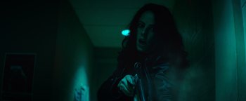 Movie still from “Resident Evil: Welcome to Raccoon City” (2021), directed by Johannes Roberts – A woman holding a cell phone in a dark room; Close Up shot, Low angle