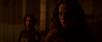 Movie still from “Resident Evil: Welcome to Raccoon City” (2021), directed by Johannes Roberts – A person in a dark room; Close Up shot, Over the shoulder angle