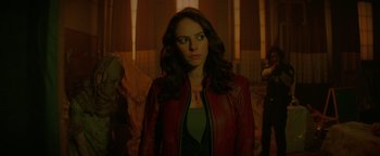 Movie still from “Resident Evil: Welcome to Raccoon City” (2021), directed by Johannes Roberts – A woman wearing a red leather jacket standing in a room; Close Up shot, Over the shoulder angle